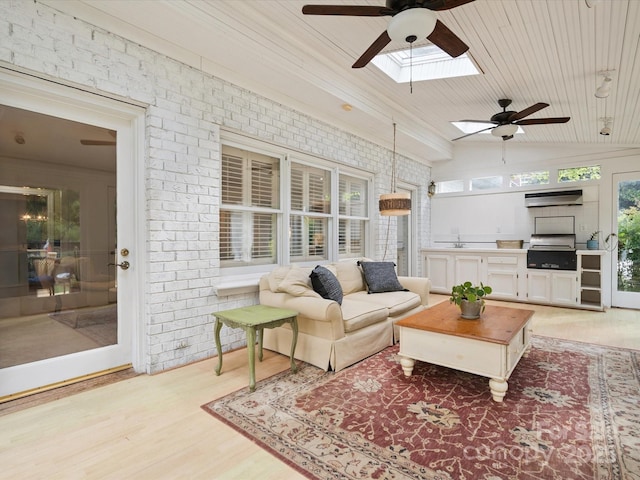 2032 Greenbrook Pkwy, Matthews, NC 28104 - living room with a ceiling fan, a skylight, brick wall, light wood-style flooring, and lofted ceiling