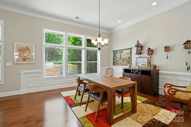 9330 Carneros Creek Rd, Charlotte, NC 28214 - dining space featuring a chandelier, wood finished floors, crown molding, a decorative wall, and wainscoting