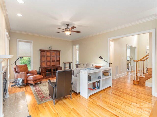 1 Hickory Rdg, Fletcher, NC 28732 - living area featuring light wood-type flooring, stairs, ceiling fan, ornamental molding, and a fireplace with flush hearth