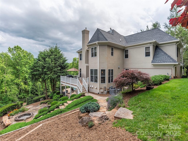 1 Hickory Rdg, Fletcher, NC 28732 - rear view of property with an outdoor fire pit, a wooden deck, stucco siding, a chimney, and roof with shingles