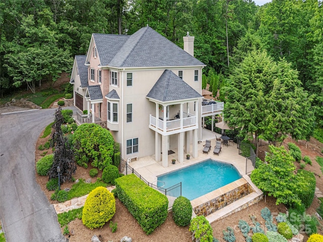 1 Hickory Rdg, Fletcher, NC 28732 - back of house featuring stucco siding, a balcony, roof with shingles, a chimney, and a patio area