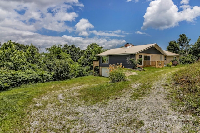 41 Remembrance Rdg, Flat Rock, NC 28731 - back of property with driveway, a wooden deck, a chimney, an attached garage, and a yard