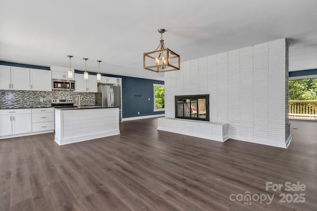 41 Remembrance Rdg, Flat Rock, NC 28731 - unfurnished living room featuring dark wood-type flooring, a chandelier, and a brick fireplace
