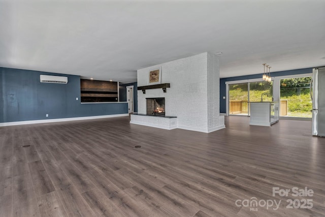 41 Remembrance Rdg, Flat Rock, NC 28731 - unfurnished living room with an AC wall unit, a brick fireplace, and dark wood-type flooring