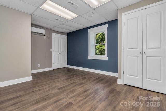 41 Remembrance Rdg, Flat Rock, NC 28731 - unfurnished bedroom featuring a wall mounted air conditioner, a paneled ceiling, and wood finished floors