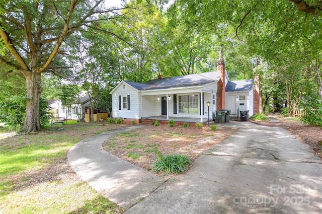 636 Forest St NW, Concord, NC 28025 - view of front of home featuring a porch, a chimney, crawl space, and roof with shingles