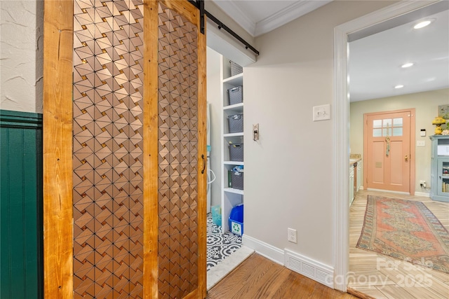 2034 Lanier Ave, Charlotte, NC 28205 - corridor featuring a barn door, light wood-type flooring, recessed lighting, and crown molding