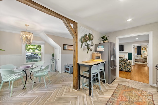 2034 Lanier Ave, Charlotte, NC 28205 - kitchen with stainless steel fridge, wainscoting, a chandelier, a fireplace, and recessed lighting