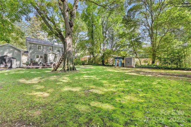 2034 Lanier Ave, Charlotte, NC 28205 - view of grassy yard featuring a storage unit and a deck