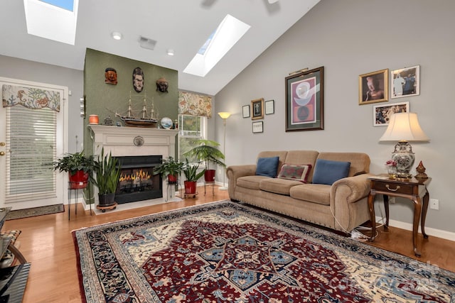 16 Sunview Cir, Arden, NC 28704 - living area featuring a skylight, a tiled fireplace, wood finished floors, and high vaulted ceiling