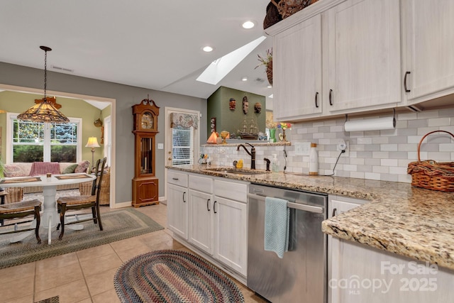 16 Sunview Cir, Arden, NC 28704 - kitchen with stainless steel dishwasher, a skylight, decorative backsplash, light tile patterned floors, and white cabinets