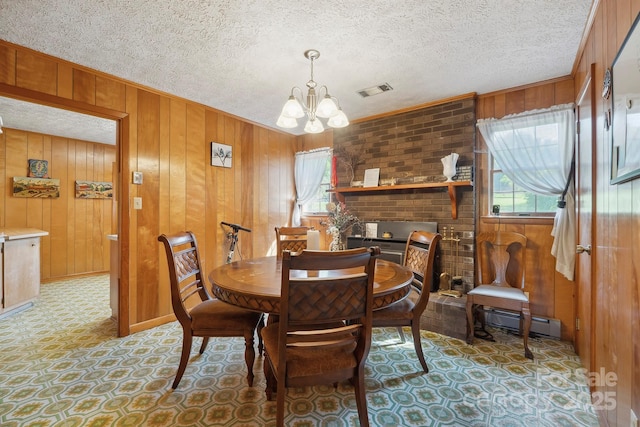 203 Shuping St, Morganton, NC 28655 - dining space featuring plenty of natural light, a chandelier, wood walls, a baseboard radiator, and light flooring