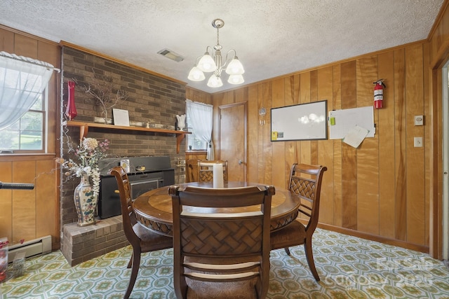 203 Shuping St, Morganton, NC 28655 - dining room featuring wooden walls, baseboard heating, a chandelier, a textured ceiling, and crown molding