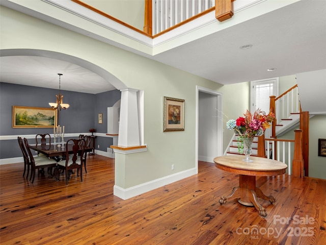303 S Braeside Ct, Asheville, NC 28803 - dining space with arched walkways, hardwood / wood-style floors, stairs, and a chandelier