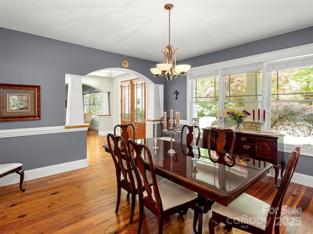303 S Braeside Ct, Asheville, NC 28803 - dining room with arched walkways, light wood-style floors, a chandelier, and plenty of natural light