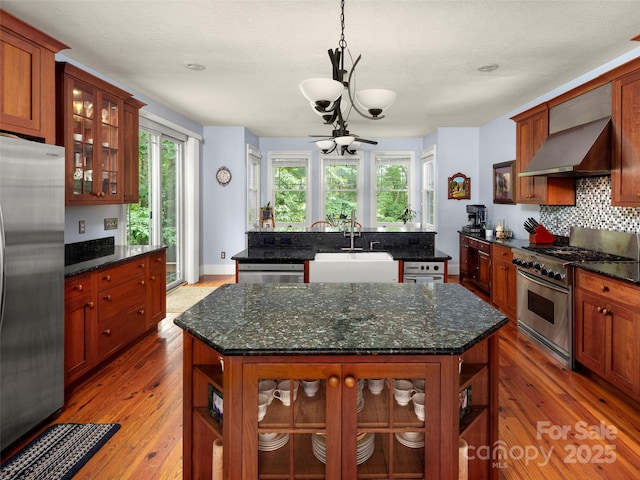 303 S Braeside Ct, Asheville, NC 28803 - kitchen featuring stainless steel appliances, a center island with sink, a chandelier, wall chimney exhaust hood, and tasteful backsplash