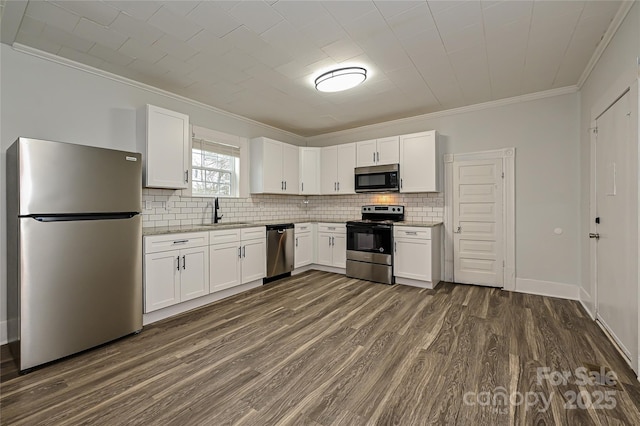 613 E Liberty St, Salisbury, NC 28144 - kitchen with appliances with stainless steel finishes, ornamental molding, decorative backsplash, dark wood-type flooring, and white cabinetry