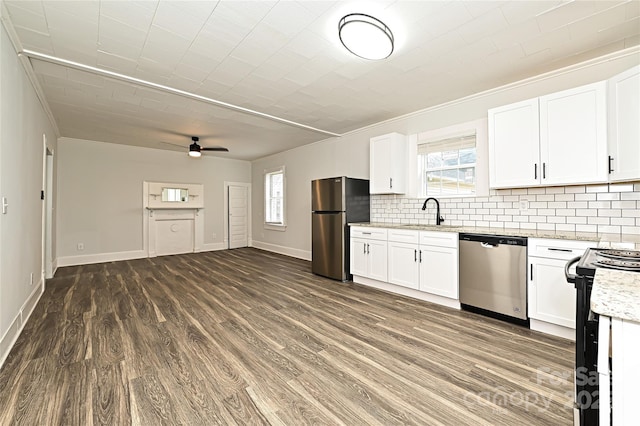 613 E Liberty St, Salisbury, NC 28144 - kitchen featuring appliances with stainless steel finishes, ornamental molding, dark wood-type flooring, ceiling fan, and decorative backsplash