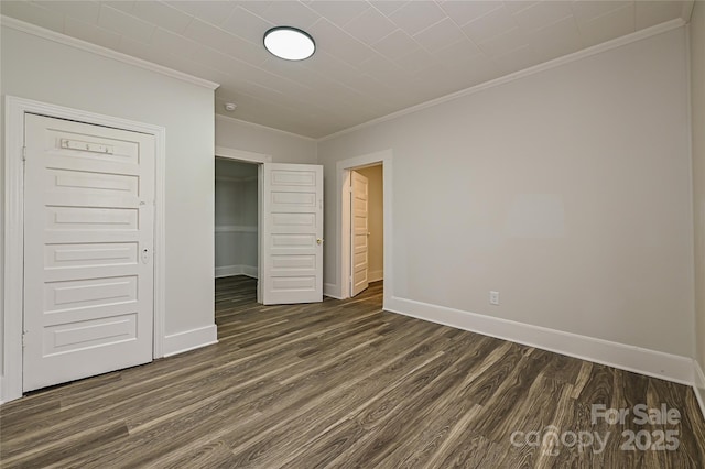 613 E Liberty St, Salisbury, NC 28144 - unfurnished bedroom featuring crown molding, dark wood-style flooring, and a closet