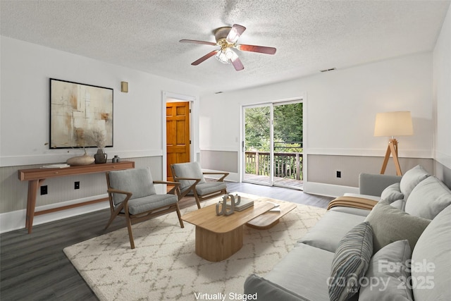 2526 Hankins Rd, Marion, NC 28752 - living room featuring a textured ceiling, wood finished floors, ceiling fan, and a wainscoted wall
