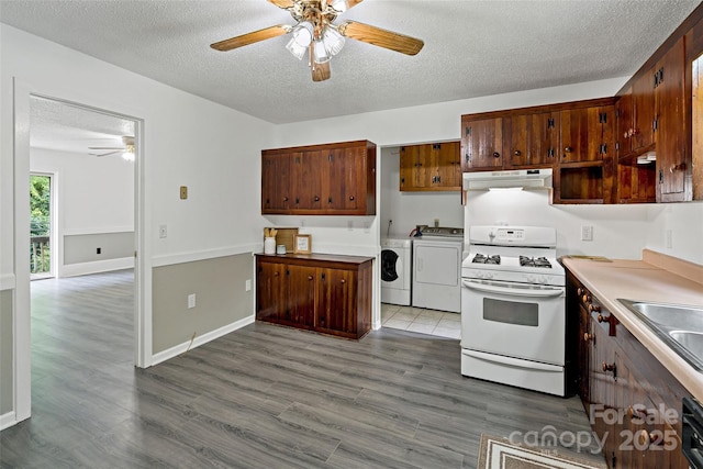 2526 Hankins Rd, Marion, NC 28752 - kitchen with gas range gas stove, washer and clothes dryer, under cabinet range hood, ceiling fan, and a textured ceiling