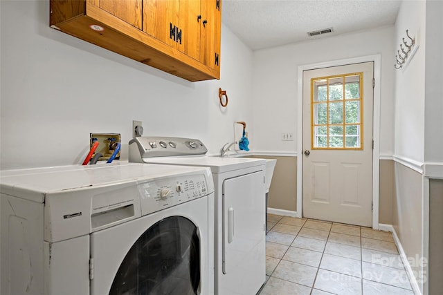 2526 Hankins Rd, Marion, NC 28752 - laundry room featuring cabinet space, washing machine and clothes dryer, light tile patterned floors, and a textured ceiling