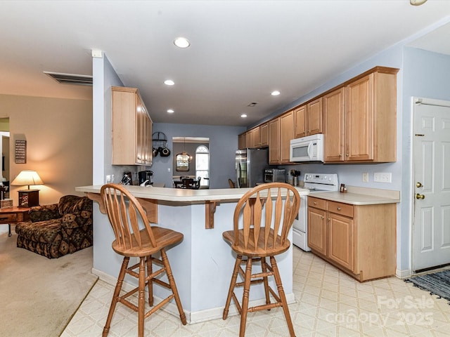 3533 Weddington Ridge Ln, Matthews, NC 28105 - kitchen featuring white appliances, a breakfast bar area, a peninsula, light countertops, and recessed lighting