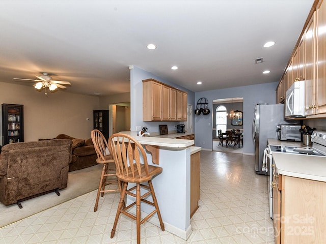 3533 Weddington Ridge Ln, Matthews, NC 28105 - kitchen featuring white microwave, range with electric stovetop, open floor plan, a kitchen breakfast bar, and ceiling fan