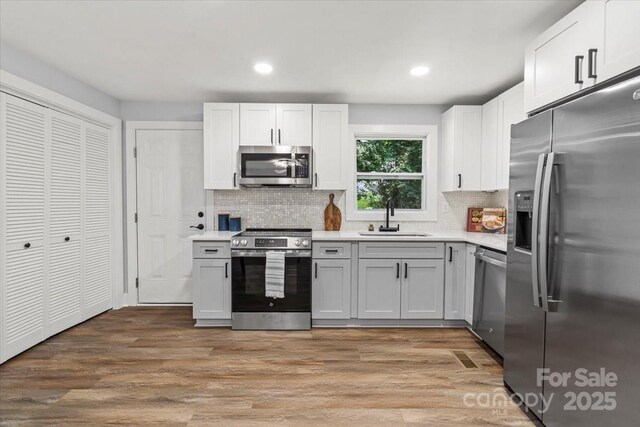 10514 Harbor Dr, Charlotte, NC 28214 - kitchen with appliances with stainless steel finishes, light countertops, backsplash, light wood-style floors, and recessed lighting