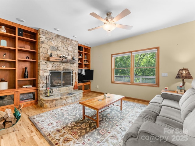 253 Sandy Ln, Brevard, NC 28712 - living room with wood finished floors, a ceiling fan, a fireplace, and built in features