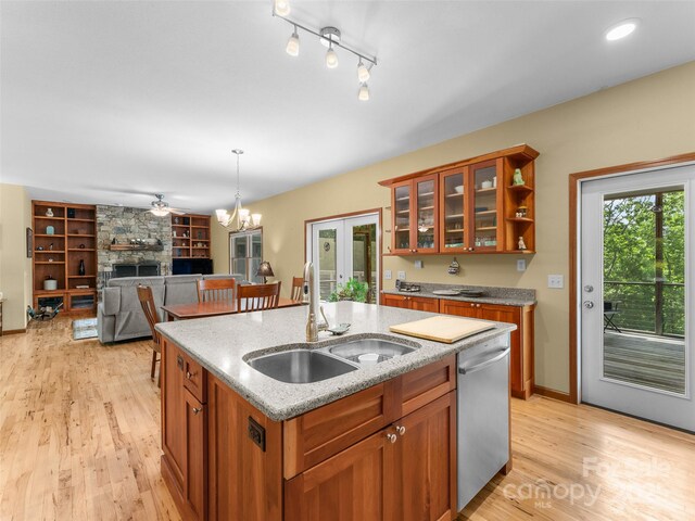 253 Sandy Ln, Brevard, NC 28712 - kitchen with stainless steel dishwasher, brown cabinets, built in features, a fireplace, and light wood-type flooring