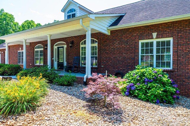4010 Carlton Dr, Claremont, NC 28610 - view of front of home with a porch, brick siding, and roof with shingles