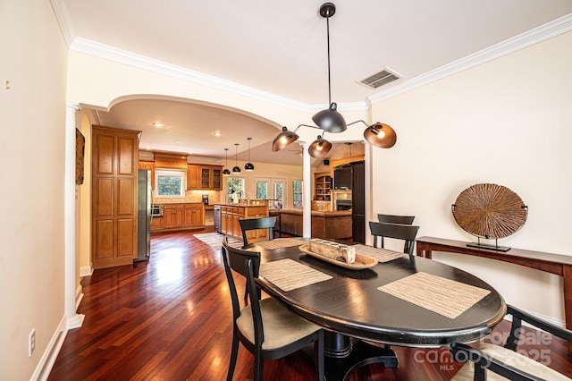 4010 Carlton Dr, Claremont, NC 28610 - dining area featuring arched walkways, ornate columns, dark wood-style flooring, and ornamental molding