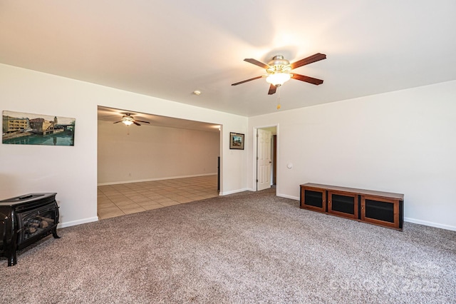 4010 Carlton Dr, Claremont, NC 28610 - unfurnished living room with a wood stove, ceiling fan, carpet, and tile patterned floors