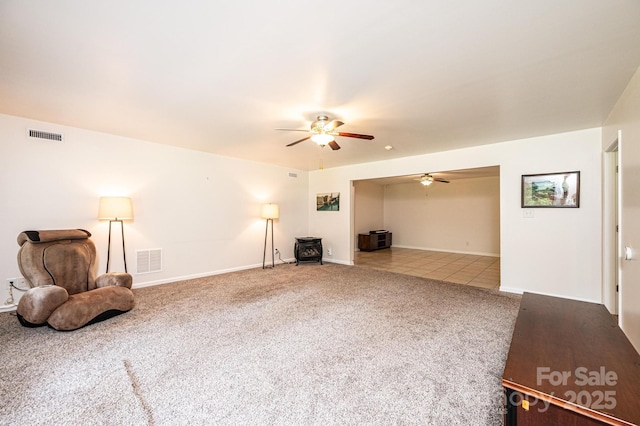 4010 Carlton Dr, Claremont, NC 28610 - unfurnished living room with carpet flooring, ceiling fan, and a wood stove