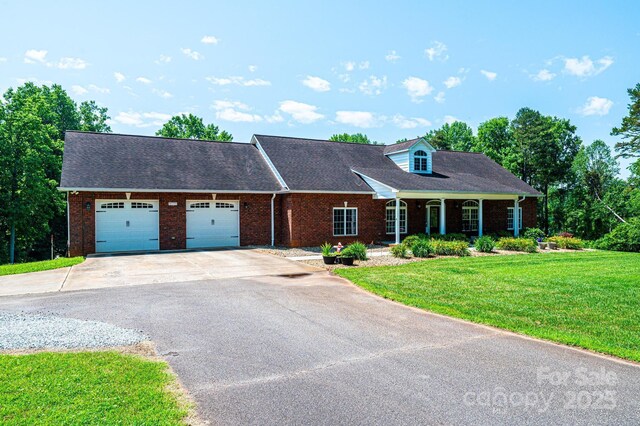 4010 Carlton Dr, Claremont, NC 28610 - cape cod-style house with asphalt driveway, brick siding, a garage, and a front yard