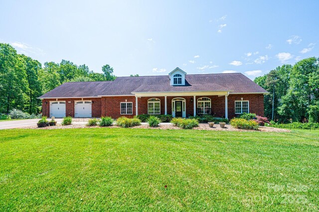 4010 Carlton Dr, Claremont, NC 28610 - view of front of house featuring concrete driveway, a front yard, an attached garage, brick siding, and a porch