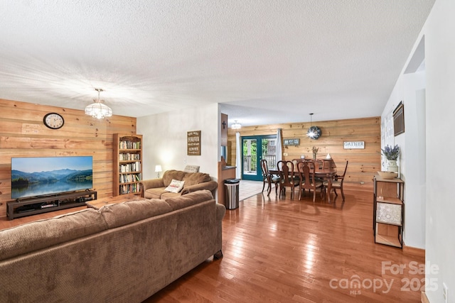 66 Ashlyn Ln, Tryon, NC 28782 - living area with wooden walls, hardwood / wood-style flooring, a chandelier, and a textured ceiling
