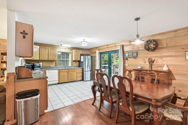 66 Ashlyn Ln, Tryon, NC 28782 - dining area featuring wood walls, a textured ceiling, and light wood-type flooring