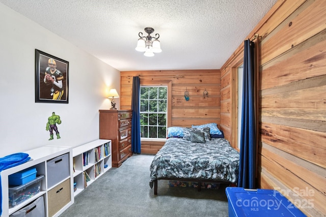66 Ashlyn Ln, Tryon, NC 28782 - bedroom featuring carpet flooring, wood walls, a textured ceiling, and a chandelier