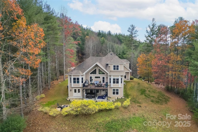 5346 Oak Crest Ln, Lenoir, NC 28645 - back of property featuring a forest view, a deck, a patio, a lawn, and a shingled roof