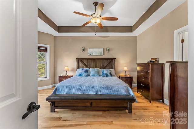 5346 Oak Crest Ln, Lenoir, NC 28645 - bedroom with light wood-type flooring, a tray ceiling, and ceiling fan