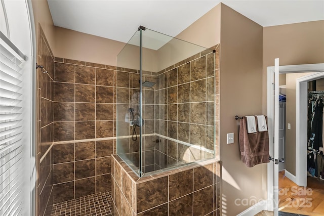 5346 Oak Crest Ln, Lenoir, NC 28645 - bathroom featuring tiled shower, a walk in closet, and wood finished floors