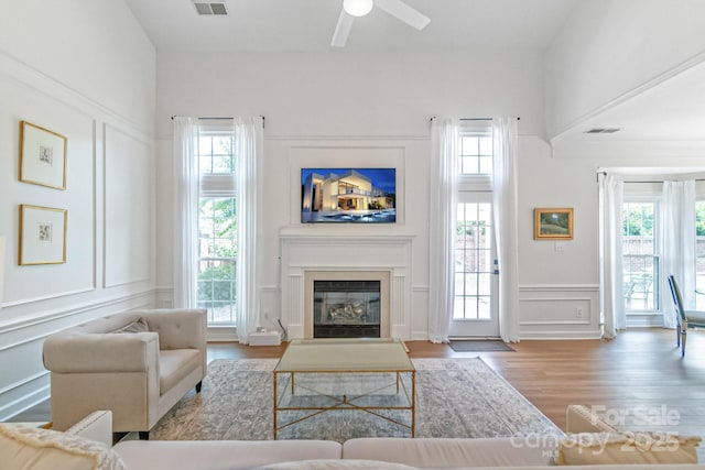 10418 Pullengreen Dr, Charlotte, NC 28277 - living room featuring a decorative wall, wood finished floors, ceiling fan, and a glass covered fireplace