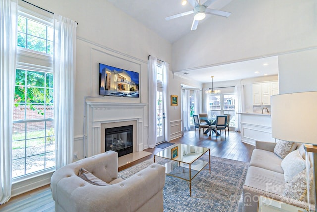 10418 Pullengreen Dr, Charlotte, NC 28277 - living area with a ceiling fan, wood finished floors, high vaulted ceiling, a glass covered fireplace, and a decorative wall