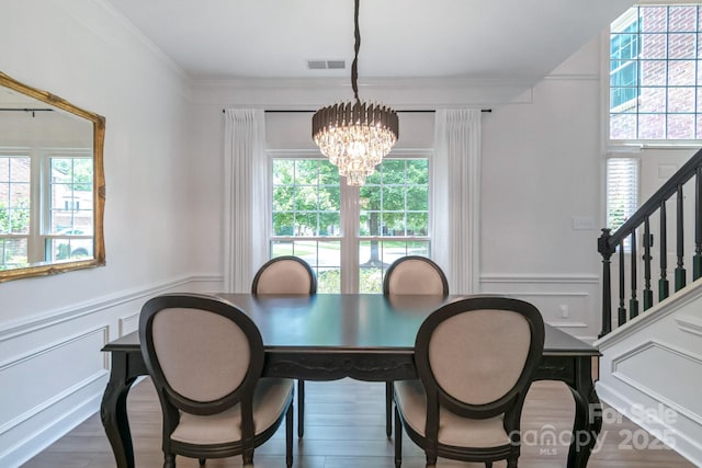10418 Pullengreen Dr, Charlotte, NC 28277 - dining area featuring plenty of natural light, a chandelier, stairs, a decorative wall, and a wainscoted wall