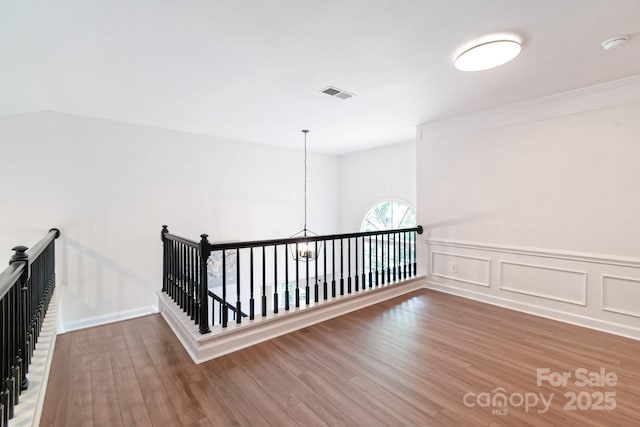 10418 Pullengreen Dr, Charlotte, NC 28277 - corridor with an upstairs landing, wood finished floors, a chandelier, and a wainscoted wall