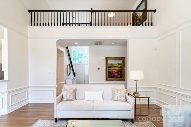 10418 Pullengreen Dr, Charlotte, NC 28277 - living room featuring a decorative wall, wood finished floors, wainscoting, and a high ceiling