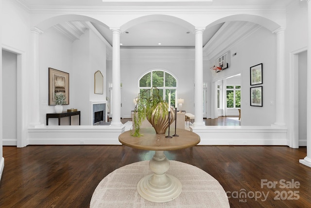 7912 Baltusrol Ln, Charlotte, NC 28210 - entrance foyer featuring wood finished floors, decorative columns, a fireplace with raised hearth, recessed lighting, and crown molding