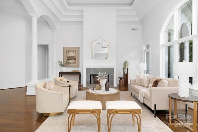 7912 Baltusrol Ln, Charlotte, NC 28210 - living room with decorative columns, wood finished floors, crown molding, a tile fireplace, and a high ceiling